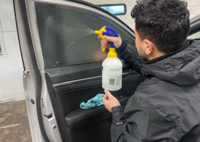 Installer applying car window tint film at Turbo Tints & Tags